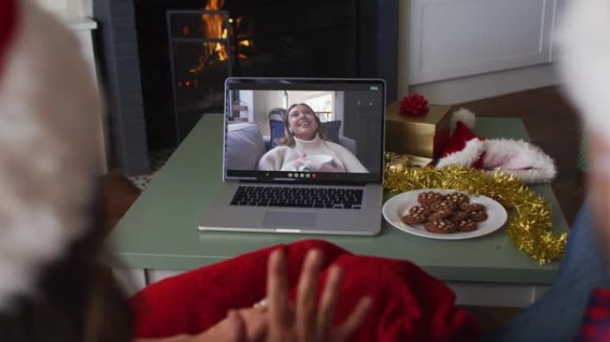 圣诞节时，快乐的高加索夫妇与女性朋友在笔记本电脑上进行视频通话