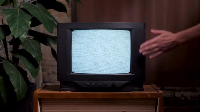 一名男子近距离撞击旧电视屏幕。80年代家用室内旧电视机。不良的电视信号噪声。无信号电视打开屏幕手敲复