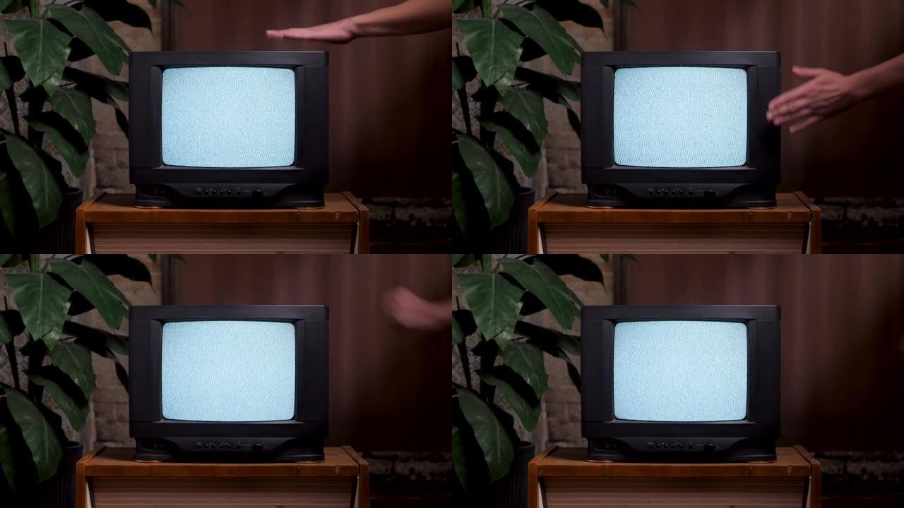 一名男子近距离撞击旧电视屏幕。80年代家用室内旧电视机。不良的电视信号噪声。无信号电视打开屏幕手敲复