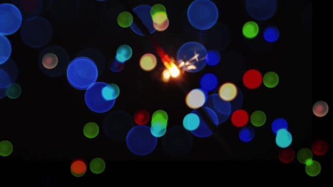 黑色背景上发光的烟火和彩色圣诞散景光点的动画
