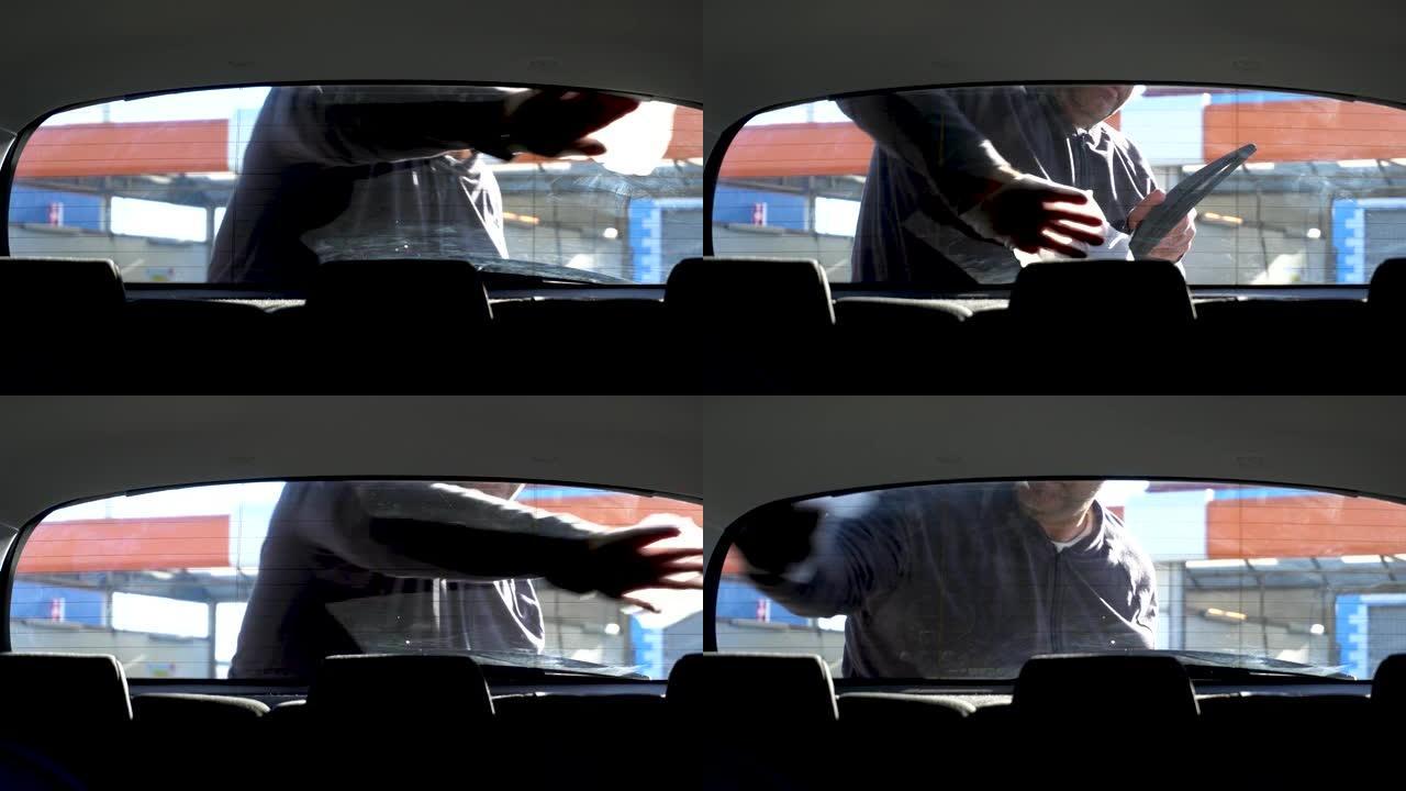 男子用布清洗汽车后窗