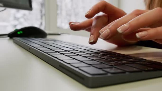 女人手动滚动鼠标并在电脑桌上的键盘上键入文本的特写视图。在线或在社交网络中搜索信息。