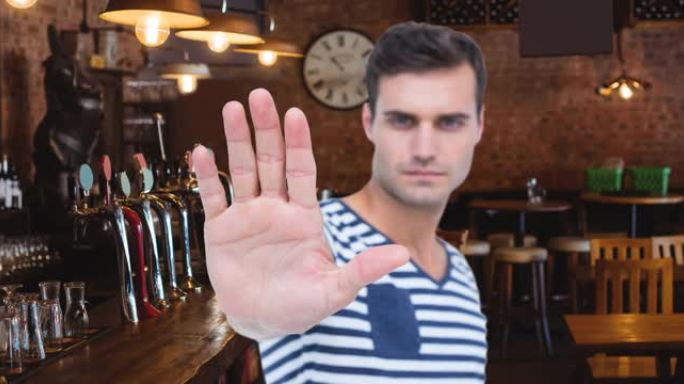 动画严肃的白人男子正在停止手的标志，在空的酒吧内部