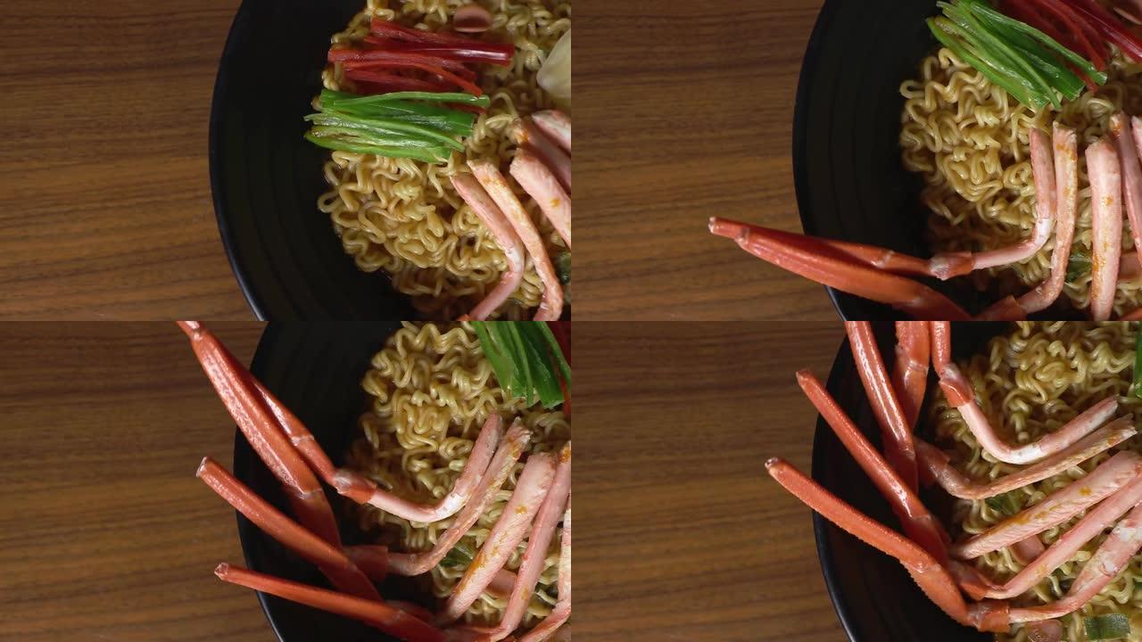 用红蟹煮的辣拉面。黑色碗里旋转的红蟹拉面。