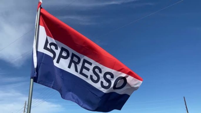 红色，白色和蓝色的旗帜，上面写着 “Espresso”，在微风中滚滚，背景为蓝天白云