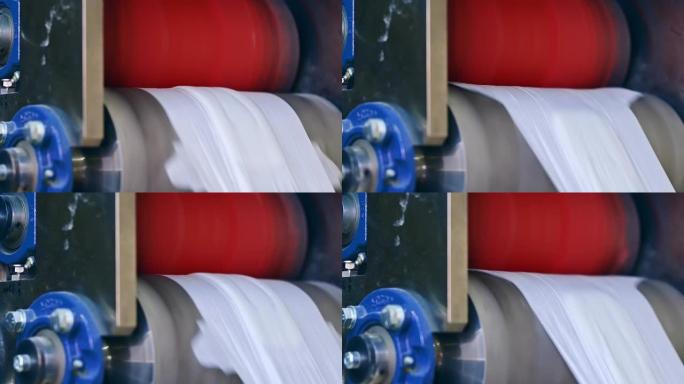 两个大轴快速旋转并移动尿布的材料。尿布生产的工艺流程。纤维在输送线上的运动。