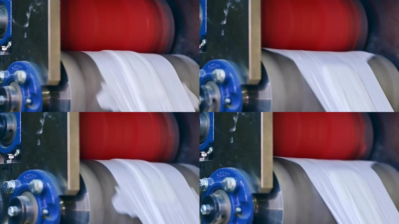 两个大轴快速旋转并移动尿布的材料。尿布生产的工艺流程。纤维在输送线上的运动。