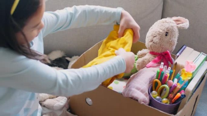 混合亚洲青年志愿者女孩整理一盒二手玩具，衣服，书籍和文具用于捐赠，快乐慈善，亚洲社区
