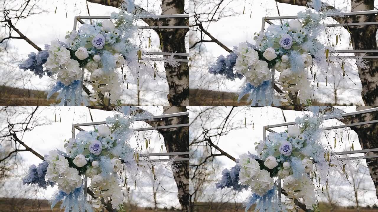 金属婚礼拱门装饰有鲜花。它们从风中移动。特写拍摄