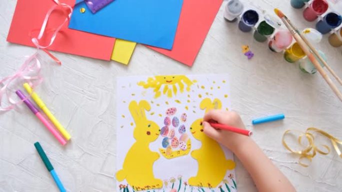 小朋友用彩色的纸制作复活节兔子卡片。贴花。手工制作的。儿童创意项目，手工艺品，儿童工艺品。