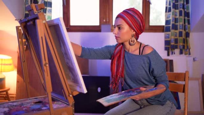 城市女艺术家在她舒适的艺术家庭工作室画布上绘画