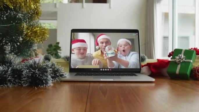 微笑的高加索家庭戴着圣诞老人的帽子在笔记本电脑上的圣诞节视频通话中
