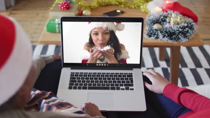 非裔美国母亲和女儿使用笔记本电脑与屏幕上的女人进行圣诞节视频通话