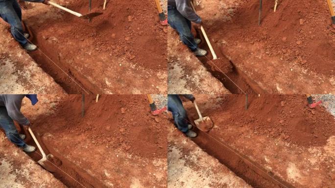 中年男子表演挖沟为房屋打基础