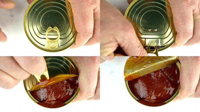 用手打开罐装沙丁鱼或鲭鱼的金属罐装番茄酱。提起金属盖。