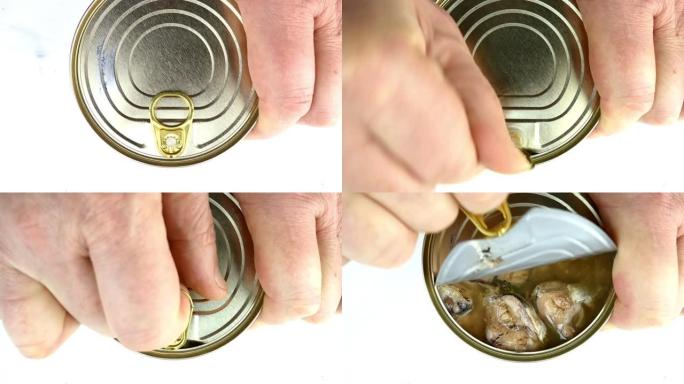 在植物油中手工打开沙丁鱼或鲭鱼罐头的金属锡罐。提起金属盖。