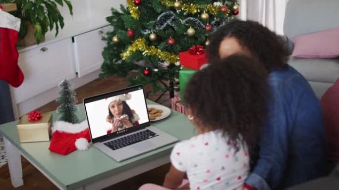 圣诞节期间，与女性朋友在笔记本电脑上进行视频通话的非洲裔美国母女快乐