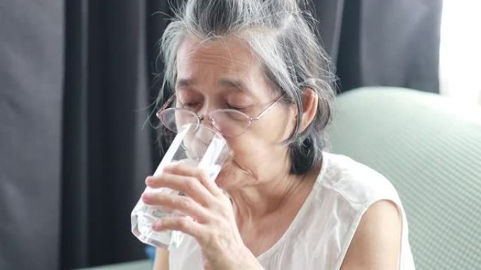 老年妇女在客厅喝水