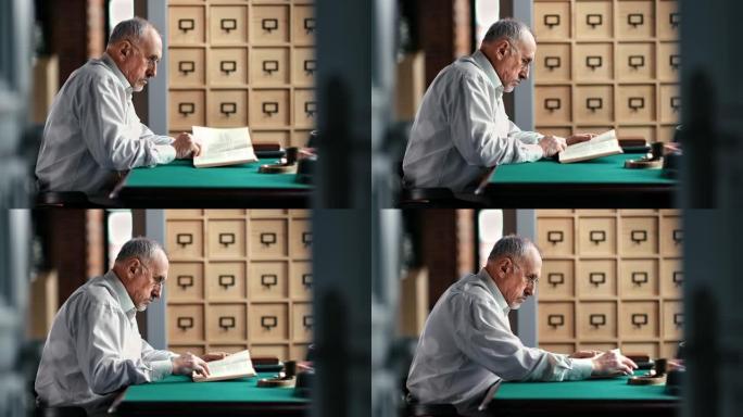 一位沉思的老人坐在复古的书桌旁读着课文纸书