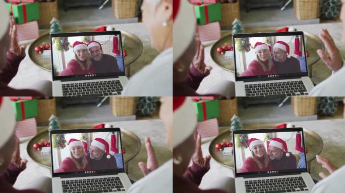 多元化的资深女性朋友使用笔记本电脑与屏幕上的情侣进行圣诞节视频通话
