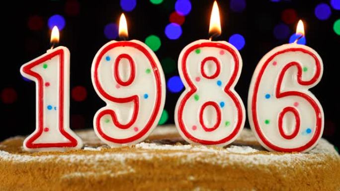 生日蛋糕与白色燃烧的蜡烛在数字1986的形式