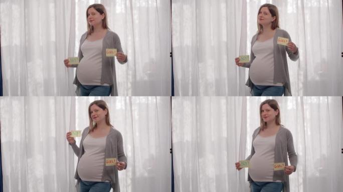 孕妇拿着两份书面性别变体的论文。