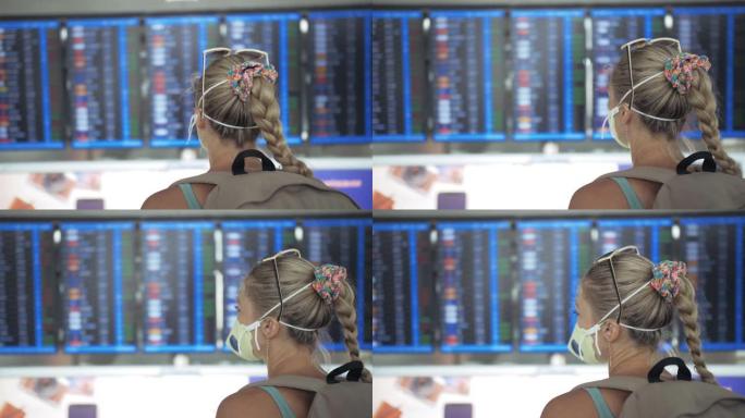 素万那普机场的白人妇女戴着防护医用口罩。飞行信息板。冠状病毒sars-cov-2新型冠状病毒肺炎