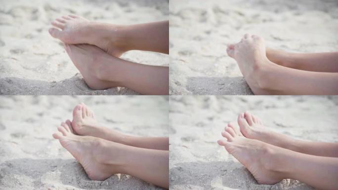 女性腿上的拇外翻在沙滩上。足关节畸形。人体的保健和医学问题
