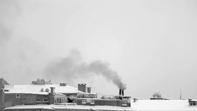 寒冷的冬天，烟囱冒烟。下雪天的镜头。屋顶覆盖着大雪。