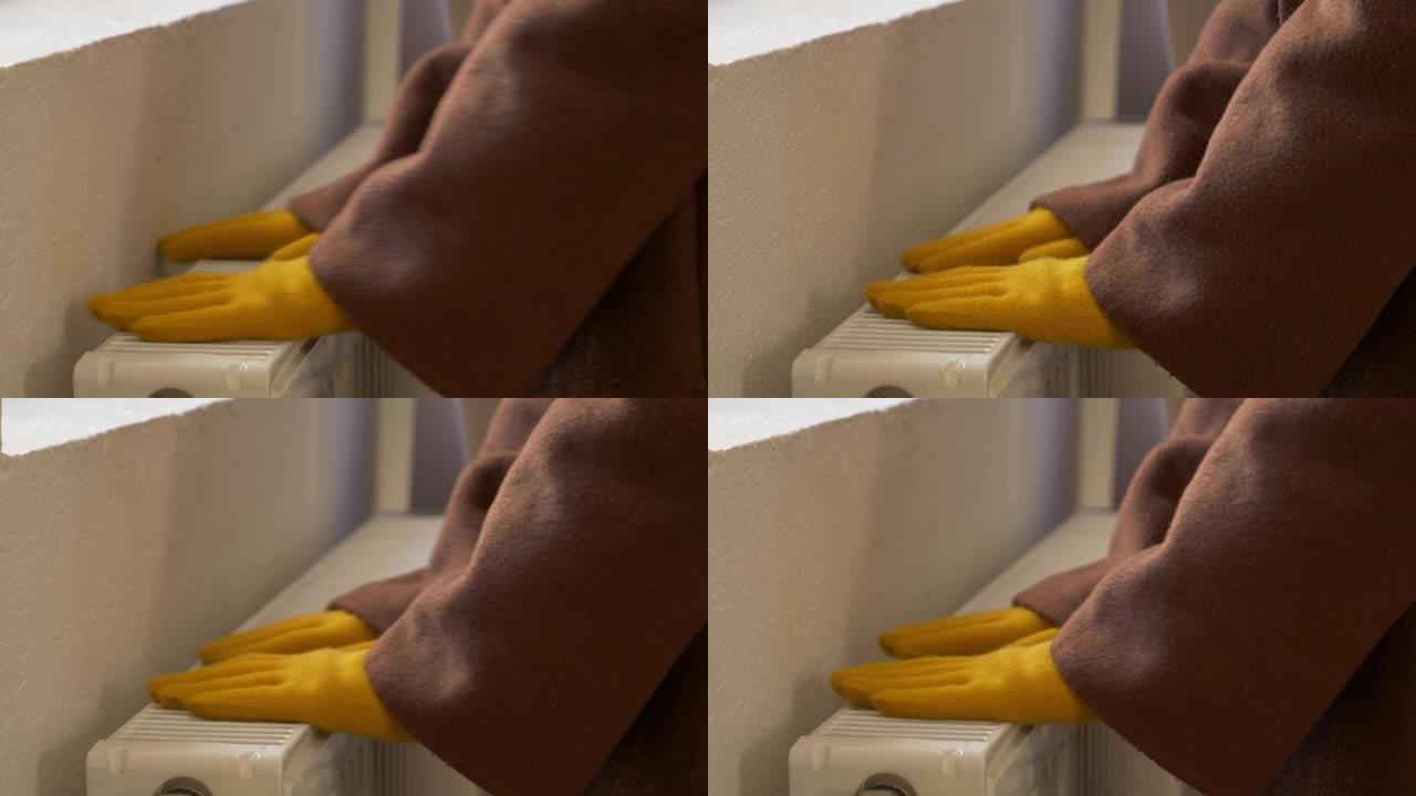 戴手套的女人在家里结冰，检查散热器是否温暖