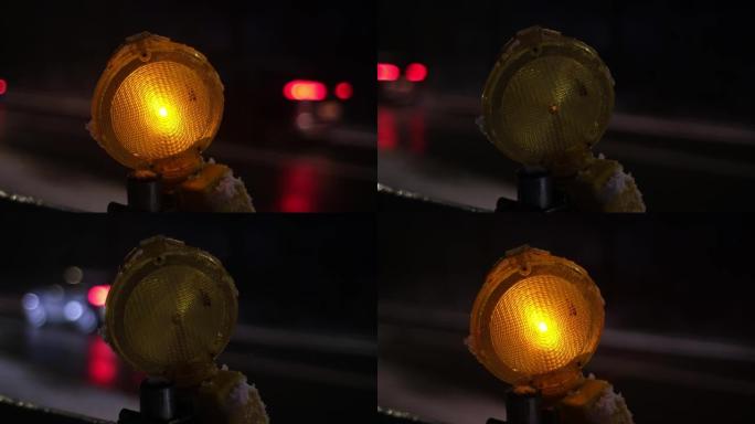 冬季傍晚交通拥挤的繁忙结冰道路上的养护道路屏障橙色警示灯依次脉动
