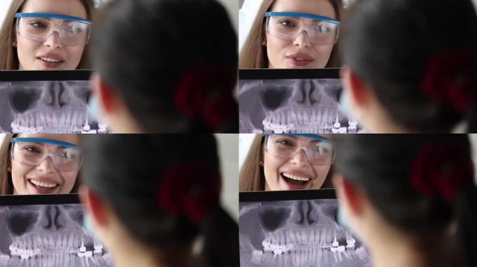牙医医生在病人4k电影前看着数字平板电脑上的牙齿全景照片