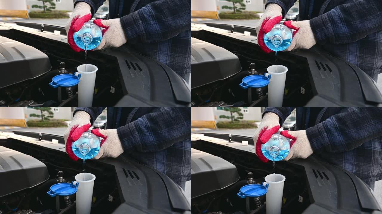 汽车维修。在汽车上加注挡风玻璃清洗液。