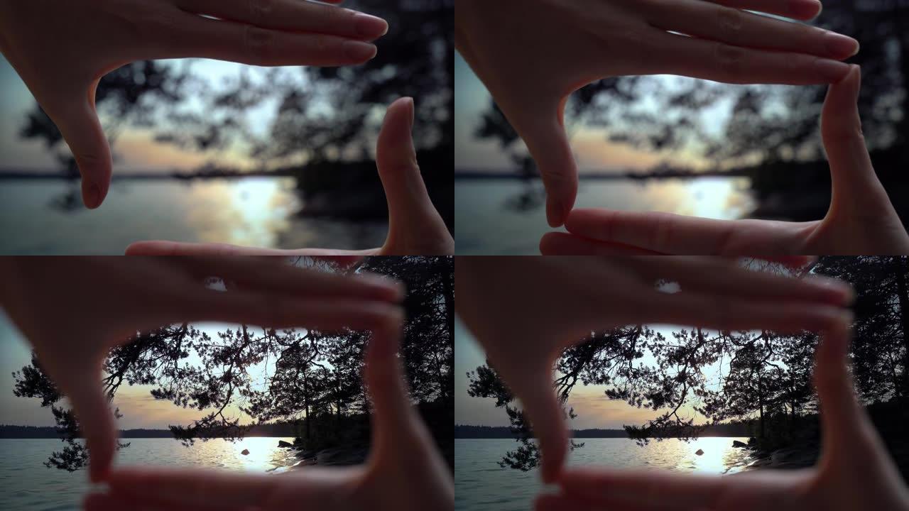 手指框架。芬兰仲夏夜的日落