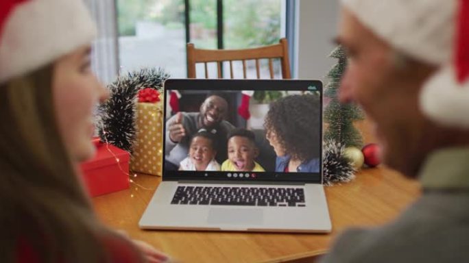 高加索人的祖父和祖父在圣诞节与家人在笔记本电脑上进行视频通话
