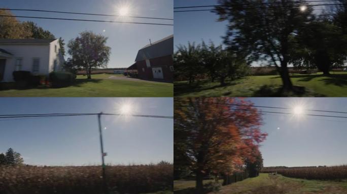 沿着美国典型的农业地区行驶，太阳照亮了房屋和田野
