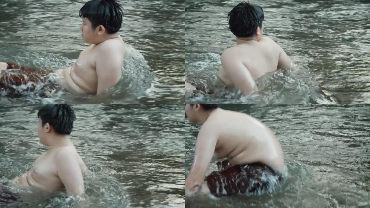 快乐的亚洲男孩在河里放松，户外生活理念。