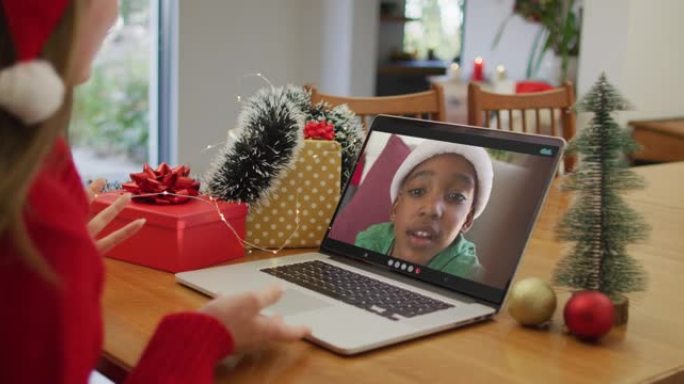 快乐的白人妇女在圣诞节与非洲裔美国男孩进行视频通话