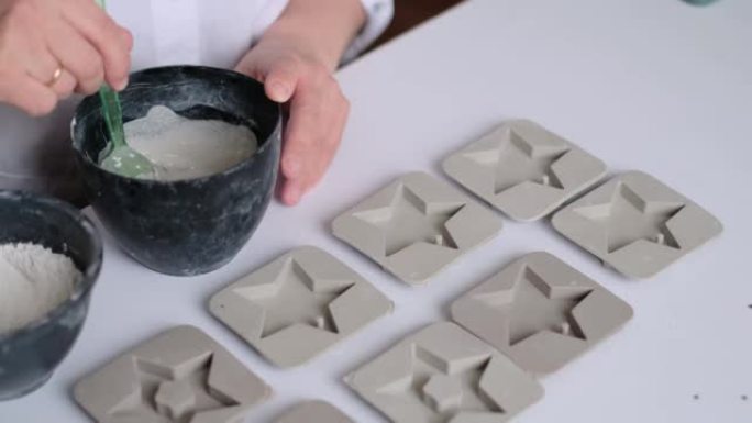 女工匠将石膏混合物倒入硅胶模具中。现代女性的创造力和自我实现