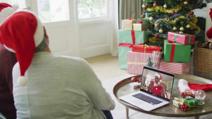 多元化的资深女性朋友使用笔记本电脑进行圣诞节视频通话，屏幕上有快乐的圣诞老人
