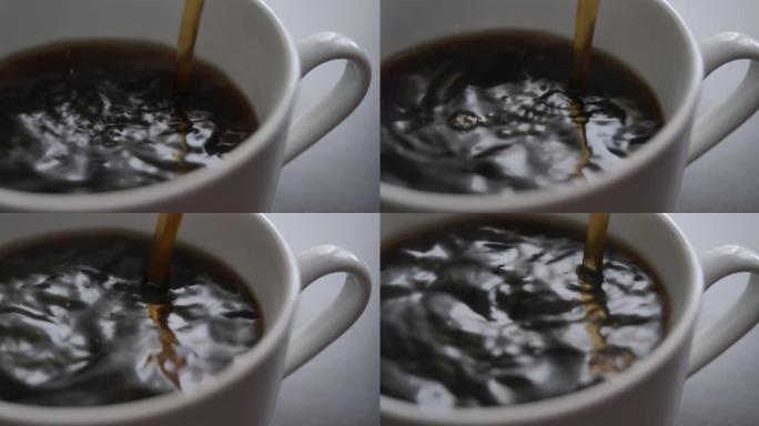 新鲜的早晨倒在红茶上特写。选择性聚焦。从咖啡机特写镜头中倒入杯中的咖啡的慢动作俯视图。慢动作将黑咖啡