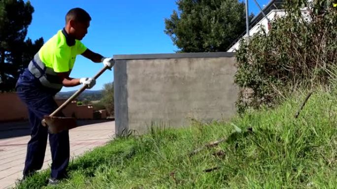 视频4k的拉丁裔男性园丁在工作服上进行挖掘和锄地维护工作。