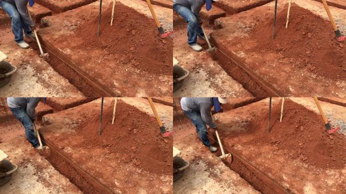 中年男子表演挖沟为房屋打基础