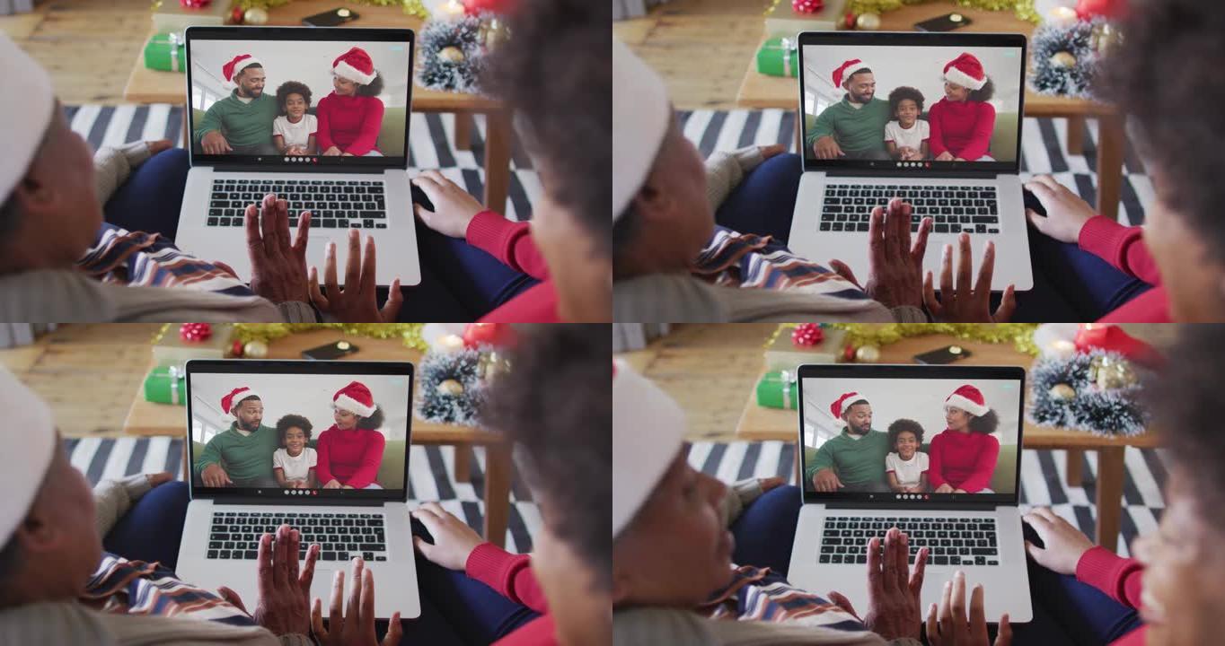 非裔美国母亲和女儿使用笔记本电脑与家人在屏幕上进行圣诞节视频通话