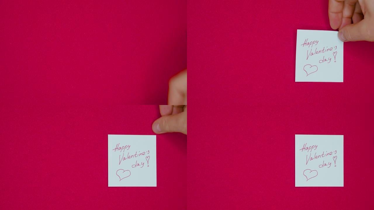 男手贴着用钢笔写的情人节快乐的字样，并在红底为情人节画了一颗心
