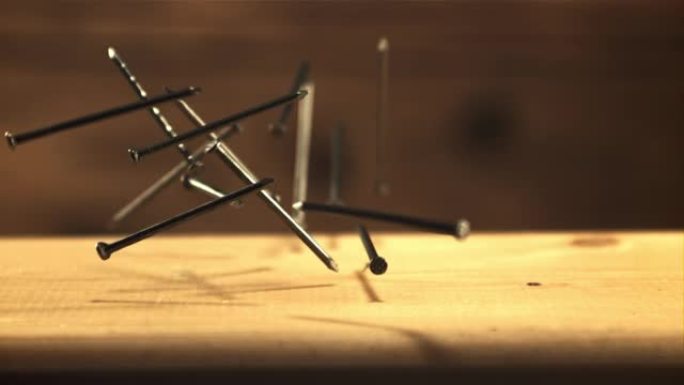 钉子落在木桌上。拍摄的是1000 fps的慢动作。