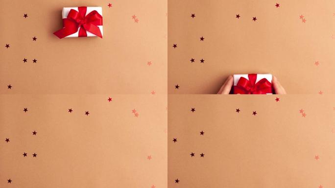 带有红色袖子的人的手拿走了一张白纸礼物，上面有一个红色缎带蝴蝶结，棕色背景上有红色星星。定格动画圣诞