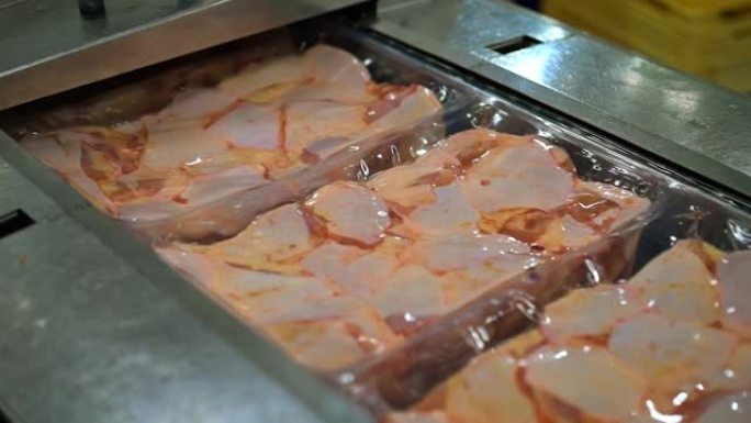 冰箱里的鸡肉。真空包装，鸡肉零件在工厂的传送带上移动。食品工业。