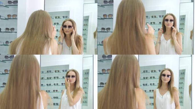 一家光学商店里的一个年轻漂亮的女孩拿起透明眼镜看视觉。女人手中的薄框时尚眼镜。女孩戴上眼镜。医疗保健