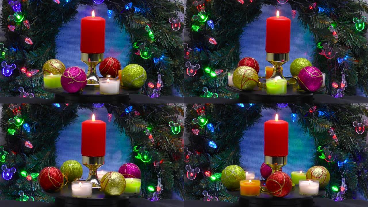 由彩球和小蜡烛包围的燃烧蜡烛在圣诞节花环和照明的背景下旋转